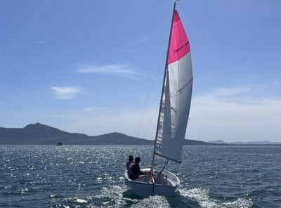 Gamba-Jolle mit rotem Segel in der Bucht von Pollença